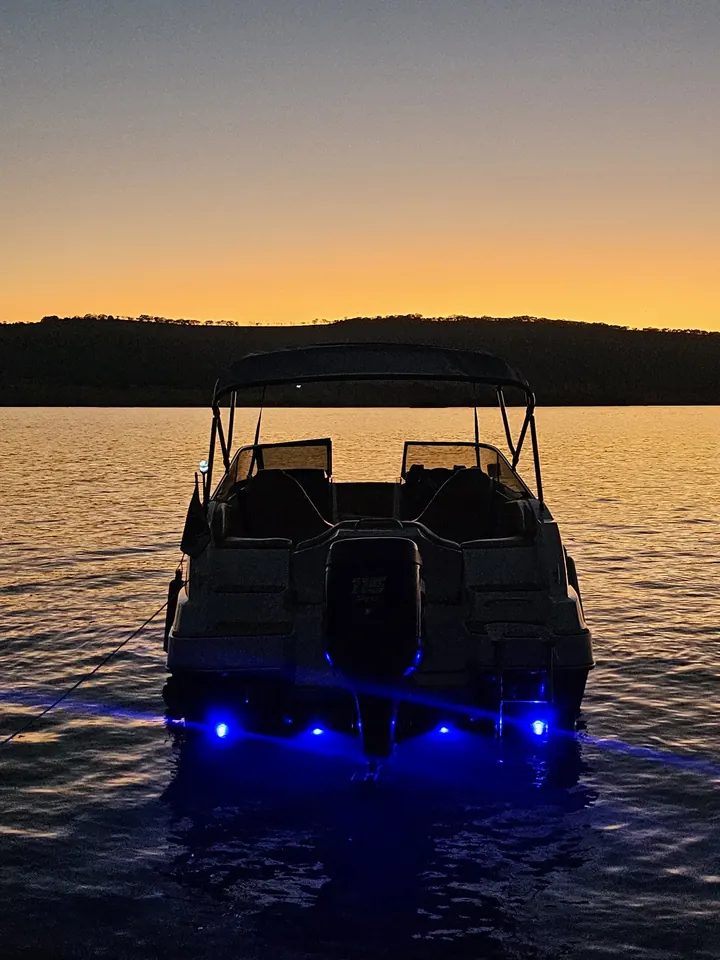 Lancha com refletores LED azuis na popa ao entardecer